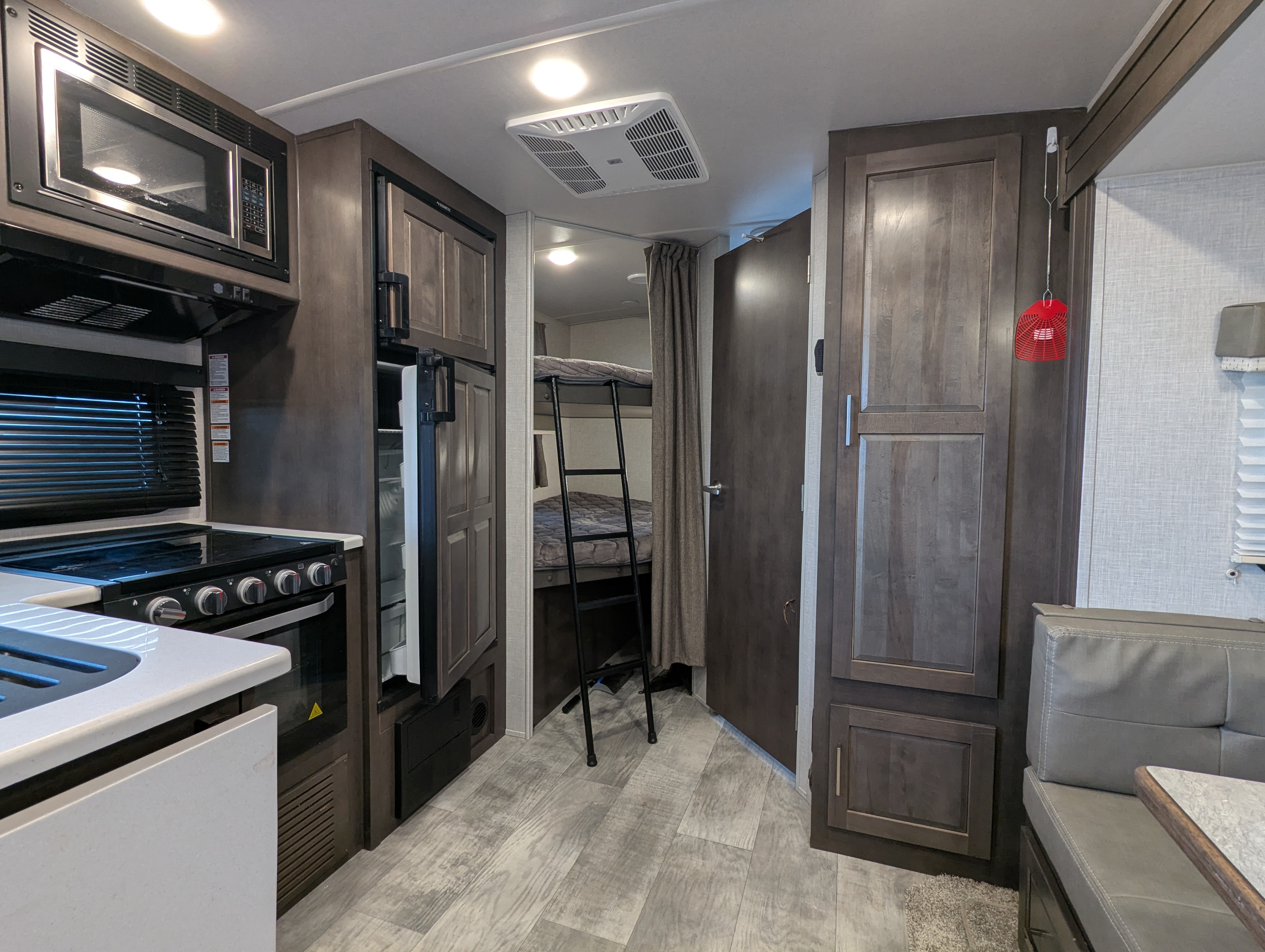 Kitchen — stove, microwave, fridge, and hallway to bunk