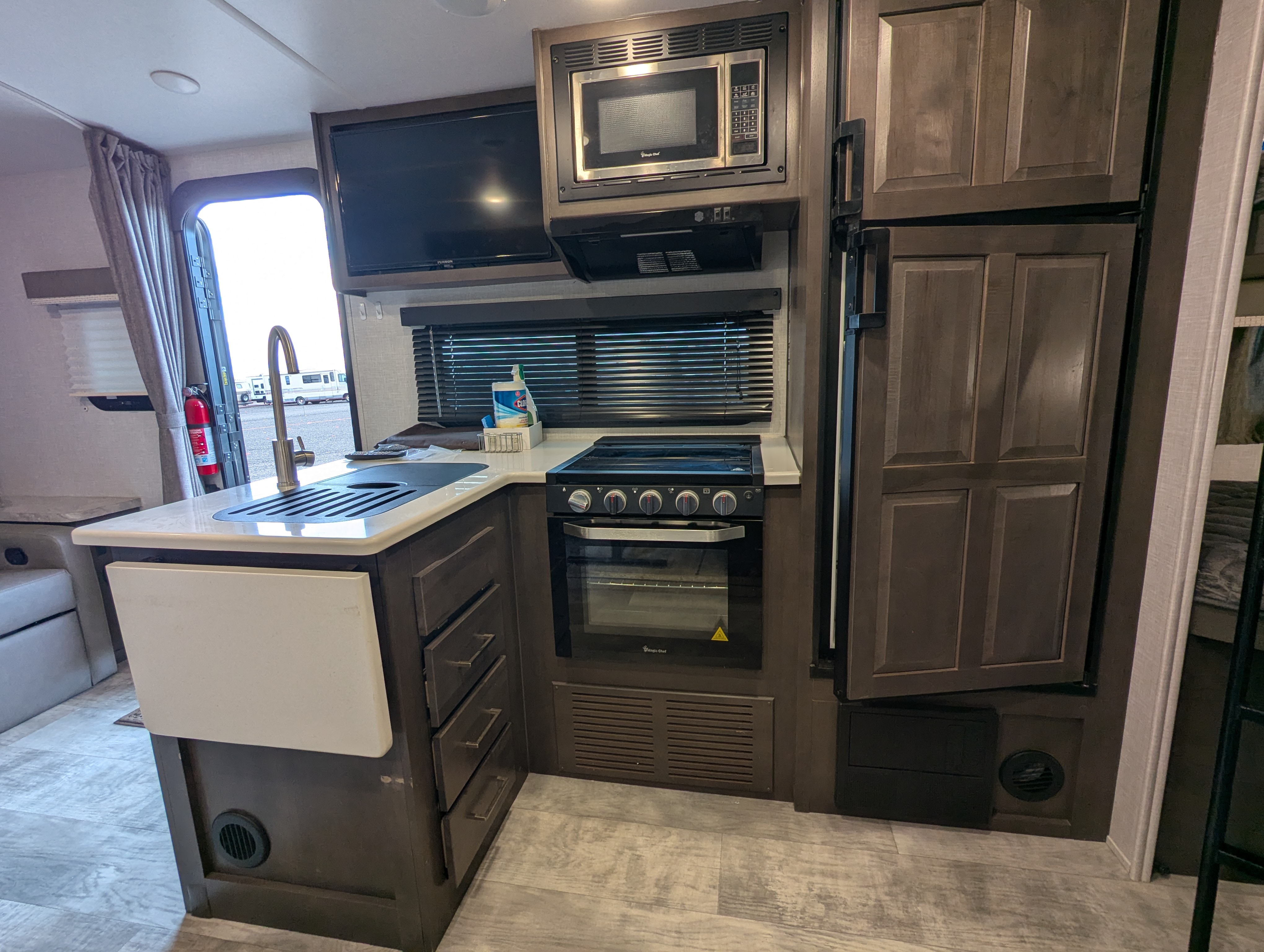 Kitchen — stove, fridge, TV, and microwave