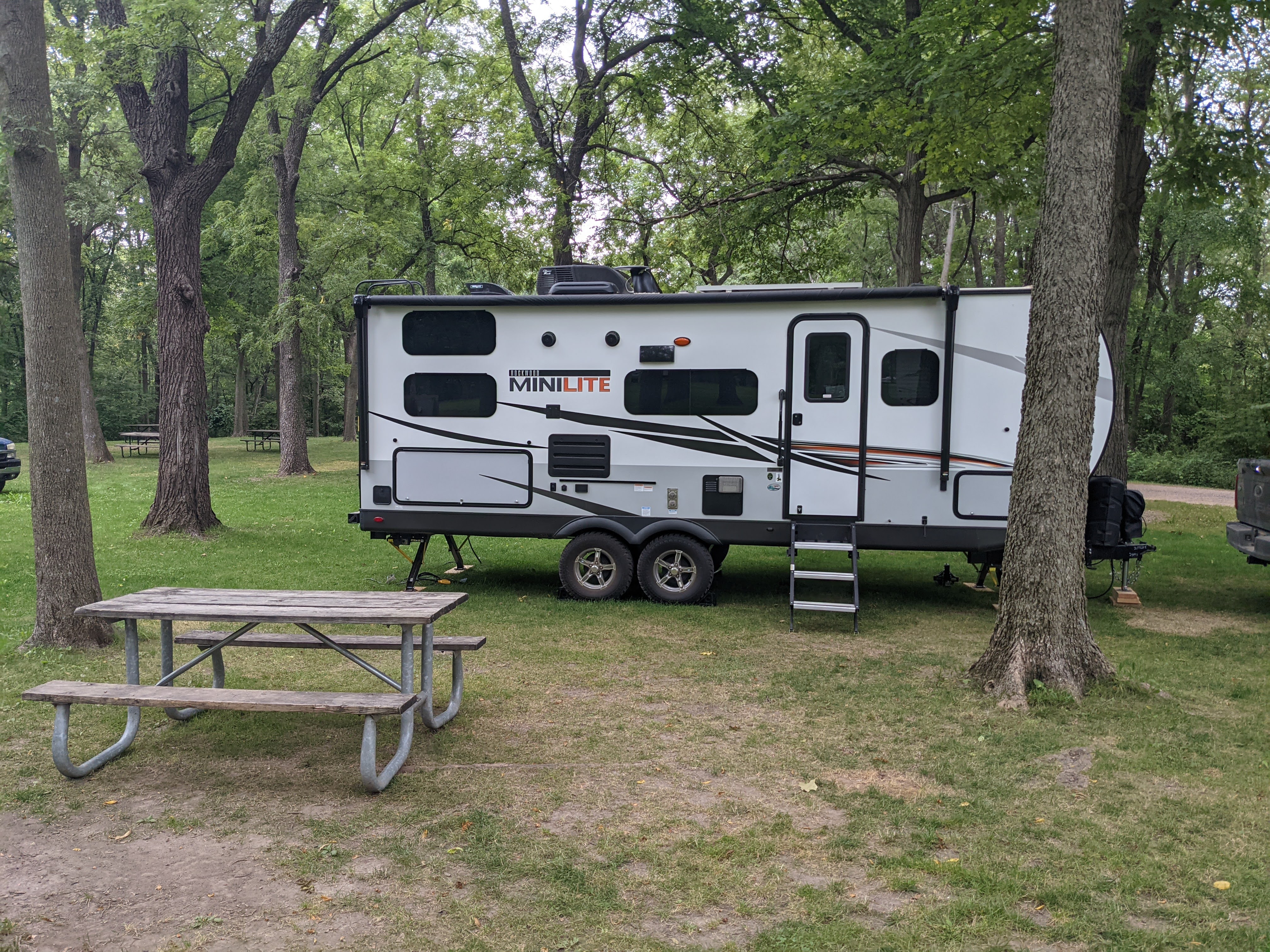 Camper set up at a wooded campground